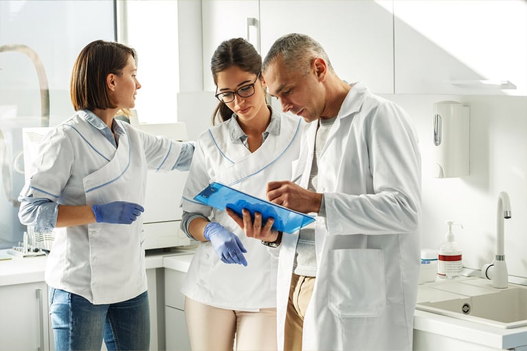 Medical dentist team in dental office discuss about practice and examining list of patients.