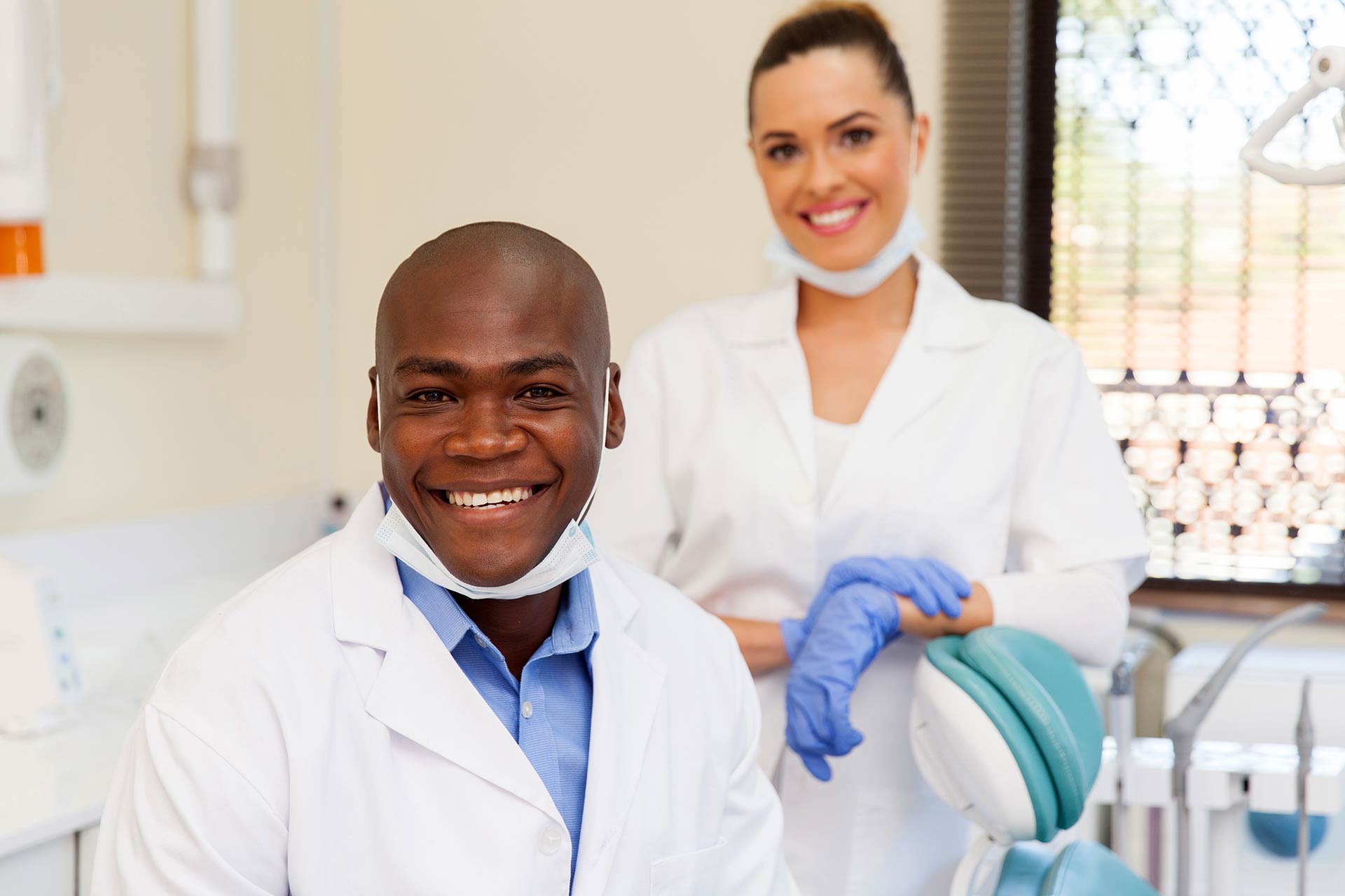 Dentist smiles next to dental hygienist 
