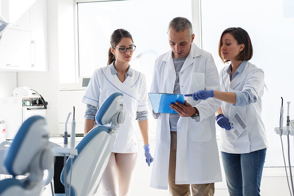 Medical dentist team in dental office examining list of patients