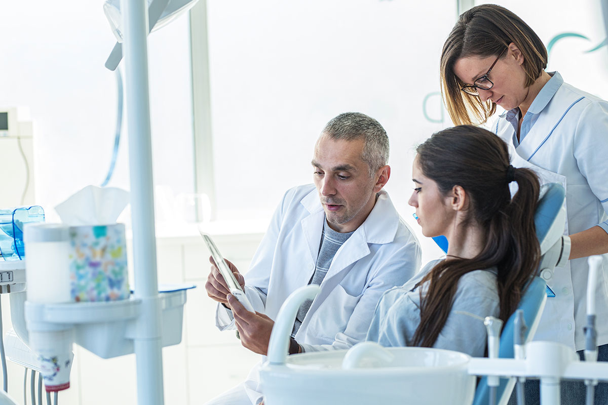 group of dentists reviewing x-rays in brightly lit room 