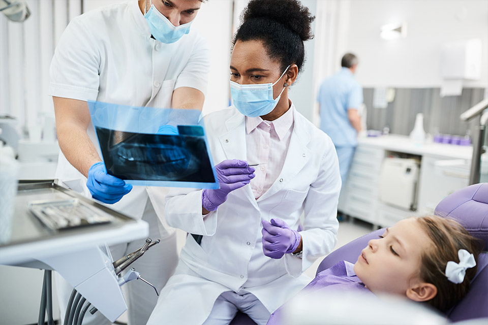 dental assistant reviewing xrays with dentist and patient