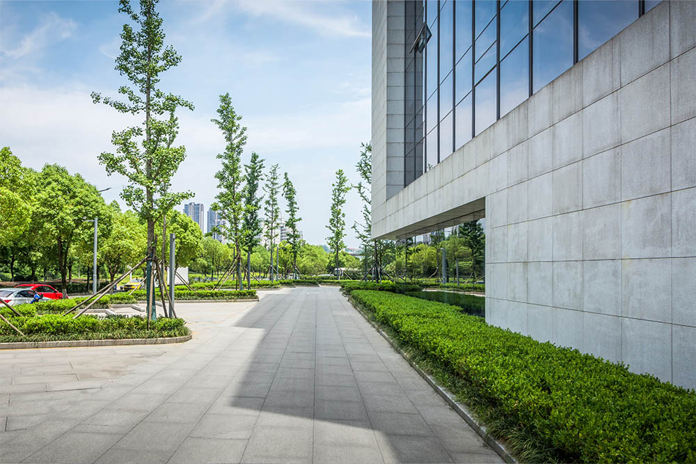 sidewalk with parking lot on the left and large medical building on the right