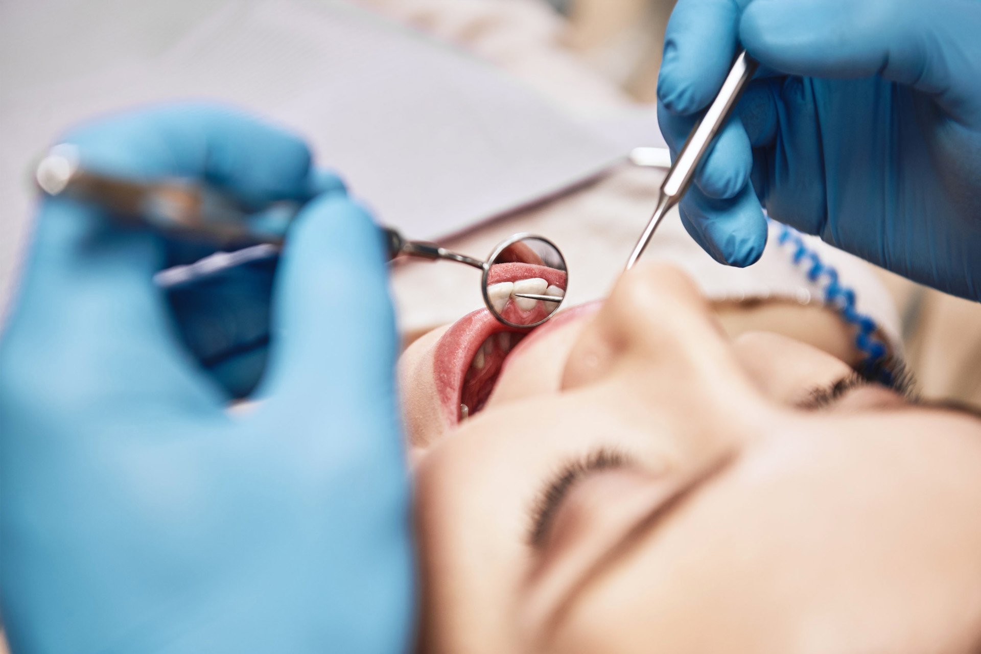 close-up of dental therapist cleaning a woman's teeth