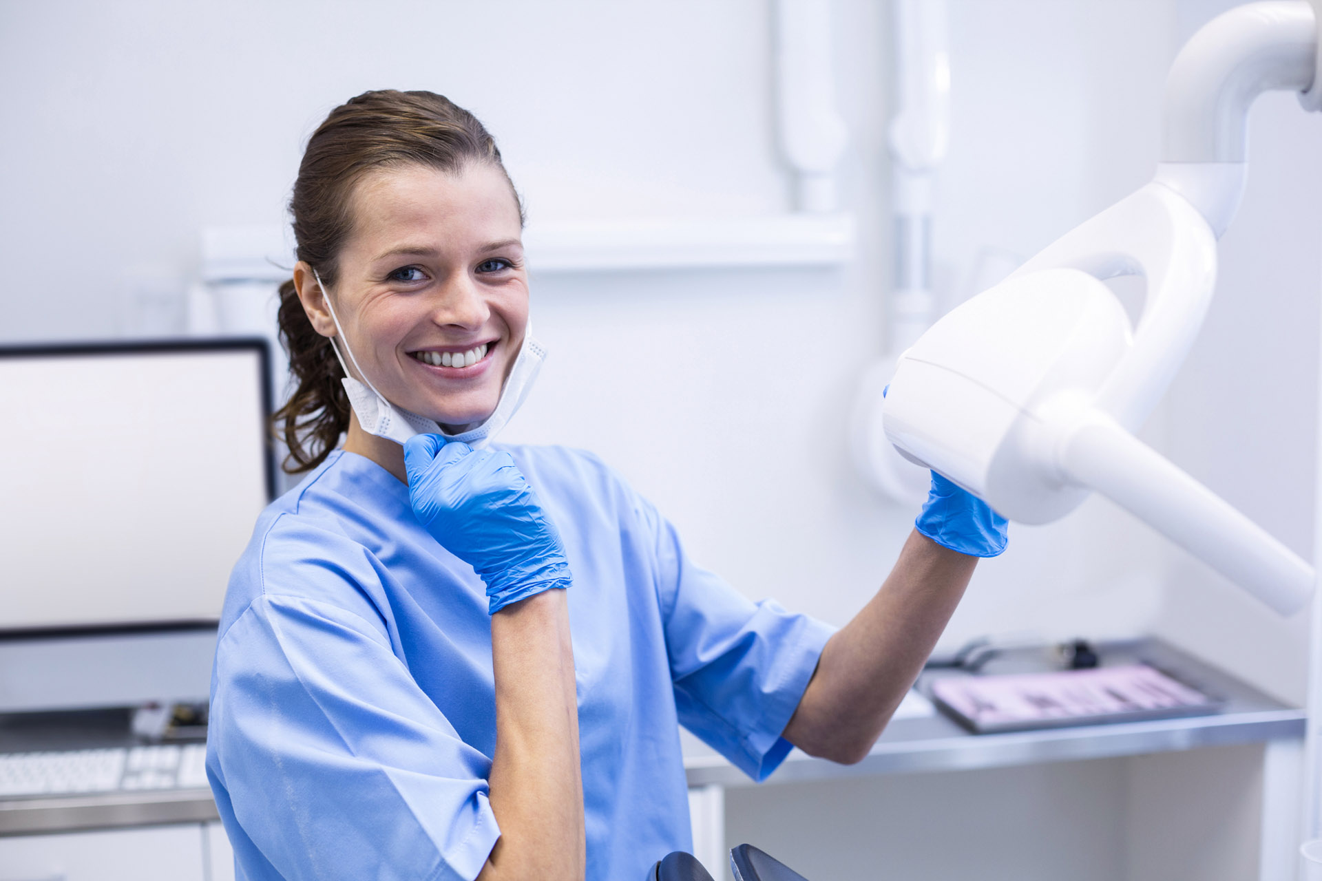 dental hygienist setting up her workstation and smiling at the camera